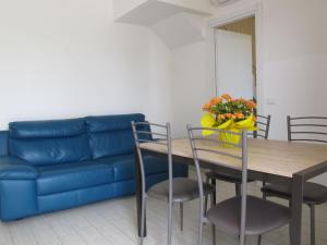 a living room with a blue couch and a table and chairs at Holiday Home Jolanda by Interhome in Bagni