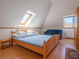 sypialnia z łóżkiem i niebieskim krzesłem w obiekcie Holiday Home Mały dworek by Interhome w Łebie