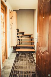 a hallway with stairs and a door and a rug at Beskidzki Zakątek in Żabnica