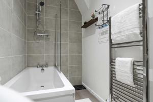 a bathroom with a white tub and a shower at New 4BedRoom Home - Near LFC & EFC in Liverpool +44 photos