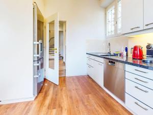 una cucina con mobili bianchi e pavimento in legno di Villa Villa Vernice Gialla by Interhome a Minusio