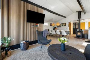 a living room with a tv on a wall at Idyllic Gem On Als Odde With Activities in Hadsund +26 photos