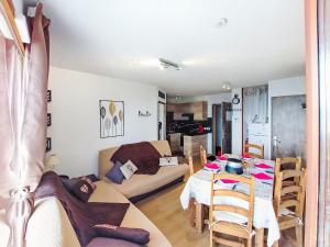 a living room with a couch and a dining room table at Apartment Bâtiment A-18 by Interhome in Le Corbier +33 photos