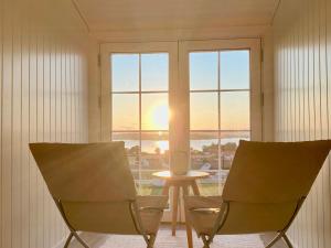 a room with two chairs and a table in front of a window at Enjoy Views In Helgeroa, Near The Beach in Helgeroa +20 photos