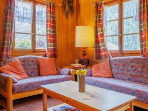 a living room with two couches and a table at Chalet Coquelicot by Interhome in Zinal