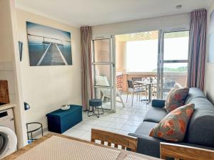 salon z niebieską kanapą i stołem w obiekcie Apartment L'Esquinade - G4 125 by Interhome w mieście Agay - Saint Raphael +37 zdjęć