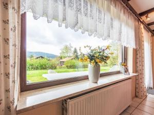 a vase of flowers sitting on a window sill at Apartment Am Hohen Bogen-11 by Interhome in Arrach