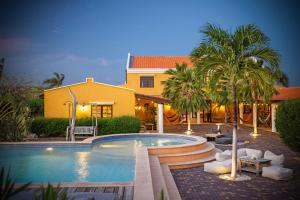 a swimming pool in front of a house at Boutique Hotel Wanapa - Adult Friendly - 14 years and older in Kralendijk