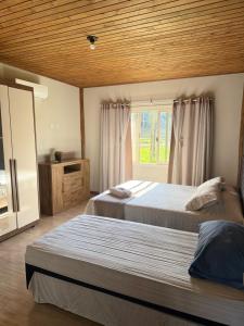 Un dormitorio con dos camas y una ventana en Refúgio Altos do Campestre - TURISMO RURAL, en Urubici