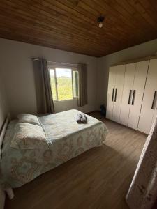 Un dormitorio con una cama grande y una ventana en Refúgio Altos do Campestre - TURISMO RURAL, en Urubici 35 fotos más