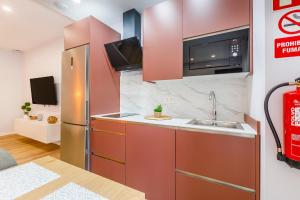 a kitchen with a refrigerator and a sink at Apartamentos Baviera Dreams in Torre del Mar