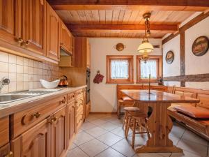 a kitchen with wooden cabinets and a wooden table at Holiday Home Sianowska Huta by Interhome in Pomieczyno