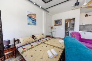 a bedroom with a bed and a couch at Palamida apartments in Banovina