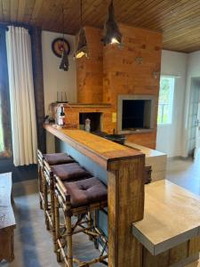 cocina con barra con taburetes y encimera en Refúgio Altos do Campestre - TURISMO RURAL, en Urubici