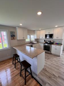 a kitchen with white cabinets and a counter top at Sun2Sand Beach House in Salisbury