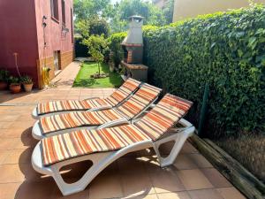 a bench sitting on a patio next to a hedge at Holiday Home La Victoria by Interhome in Palafrugell