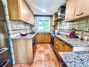 a kitchen with wooden cabinets and granite counter tops at Holiday Home La Victoria by Interhome in Palafrugell
