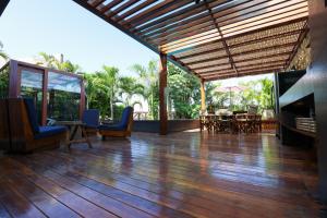 an outdoor deck with chairs and a table and a fireplace at Casa dos Corais Patacho in Pôrto de Pedras