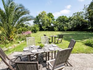 a wooden table and chairs in a garden at Holiday Home Feliz Breizh by Interhome in Plounévez-Lochrist