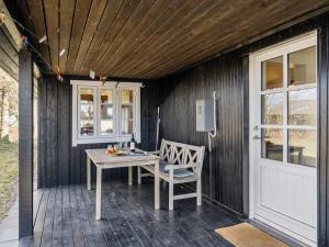 a wooden table and a chair on a patio at Holiday Home Githe - from the sea by Interhome in Hals