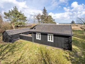 a black house on a grassy field at Holiday Home Githe - from the sea by Interhome in Hals