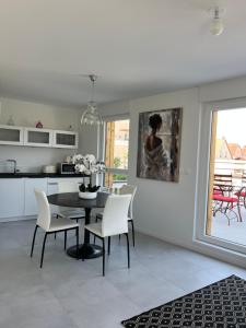 une cuisine et une salle à manger avec une table et des chaises dans l'établissement La Terrasse du Vignoble - Garage et parking privatifs, à Barr