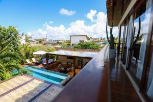 a balcony of a house with a swimming pool at Casa dos Corais Patacho in Pôrto de Pedras