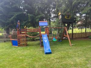 a set of playground equipment in a yard at POGO dom nad Narwią - 4 sypialnie, duża sauna, balia, pomost, plac zabaw in Pogorzelec +73 photos