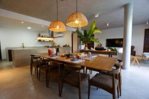 a kitchen and dining room with a wooden table and chairs at Casa dos Corais Patacho in Pôrto de Pedras