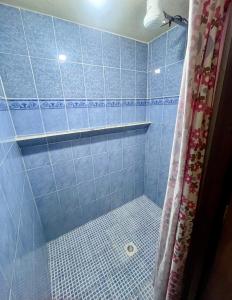 a bathroom with a blue tiled shower with a shower curtain at Jireh guesthouse in Antigua Guatemala +37 photos