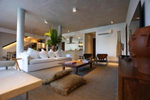 a living room with a white couch and a table at Casa dos Corais Patacho in Pôrto de Pedras
