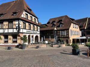 un groupe de bâtiments sur une place de ville dans l'établissement La Terrasse du Vignoble - Garage et parking privatifs, à Barr