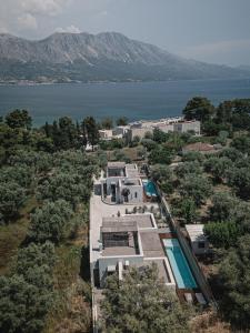an aerial view of the house and the water at NIMA Suites in Paleros +59 photos
