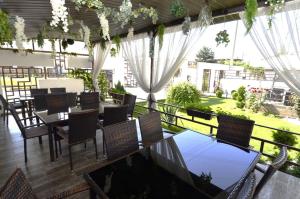 a restaurant with tables and chairs and a balcony at Vila Bliss in Costinesti