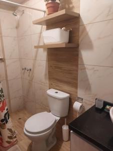 a bathroom with a white toilet and a black counter at Amplio departamento en Ica in Ica