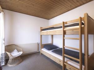 a bedroom with two bunk beds and a chair at Holiday Home Landhaus Rittisweid by Interhome in Schladming
