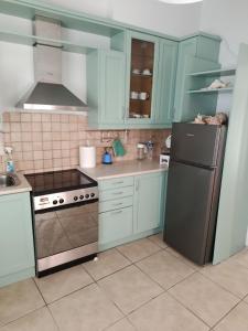 a kitchen with blue cabinets and a stainless steel refrigerator at House 8 in Ermoupoli