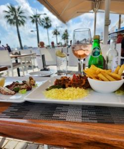 a table with two plates of food and a glass of wine at Onero Residence Lovely Apartment in Paphos City