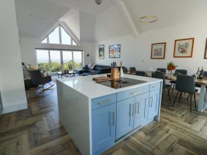 a kitchen with a counter and a living room at Golygfa Gele in Abergele