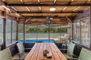 an outdoor dining room with a wooden table and chairs at שיר החורש in Shomera