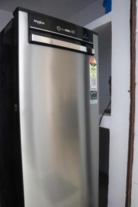 a stainless steel refrigerator in a kitchen at Bollywood House 100 inch Cinema Jacuzzi Party Couples in Gurgaon