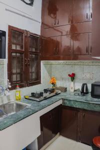 a kitchen with wooden cabinets and a sink and a stove at Bollywood House 100 inch Cinema Jacuzzi Party Couples in Gurgaon