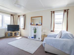 ein Wohnzimmer mit einem Bett und einem Fernseher in der Unterkunft Lazy Days in Padstow