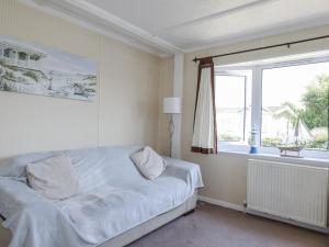 ein weißes Schlafzimmer mit einem Bett und einem Fenster in der Unterkunft Lazy Days in Padstow