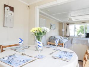ein weißer Tisch mit einer Vase Blumen drauf in der Unterkunft Lazy Days in Padstow