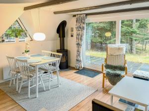 a living room with a table and chairs at Summerhouse By The North Sea in Vestervig