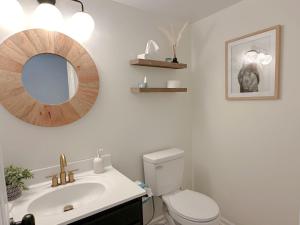 a bathroom with a toilet and a sink and a mirror at NH515 Club Paradise in Nags Head +23 photos