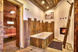 a bathroom with a bath tub and a fireplace at Cabin In The Nature Of Bavaria in Schöllnach