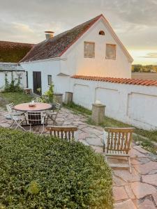 eine Terrasse mit Tisch und Stühlen und ein Gebäude in der Unterkunft Charming Farmhouse With Open Spaces Near Österlen in Löderup