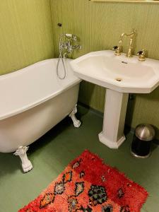 ein Badezimmer mit einem Waschbecken und einer Badewanne neben einem Waschbecken in der Unterkunft Charming Farmhouse With Open Spaces Near Österlen in Löderup